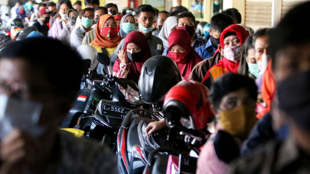 Ratusan orang antre mengurus perpanjangan Surat Ijin Mengemudi (SIM) di layanan SIM keliling di Pasar Tambak Rejo, Surabaya, Jawa Timur, Selasa (9/6/2020). Foto: Didik Suhartono/ANTARA FOTO