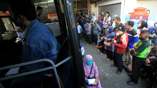 Ratusan orang antre mengurus perpanjangan Surat Ijin Mengemudi (SIM) di layanan SIM keliling di Pasar Tambak Rejo, Surabaya, Jawa Timur, Selasa (9/6/2020). Foto: Didik Suhartono/ANTARA FOTO