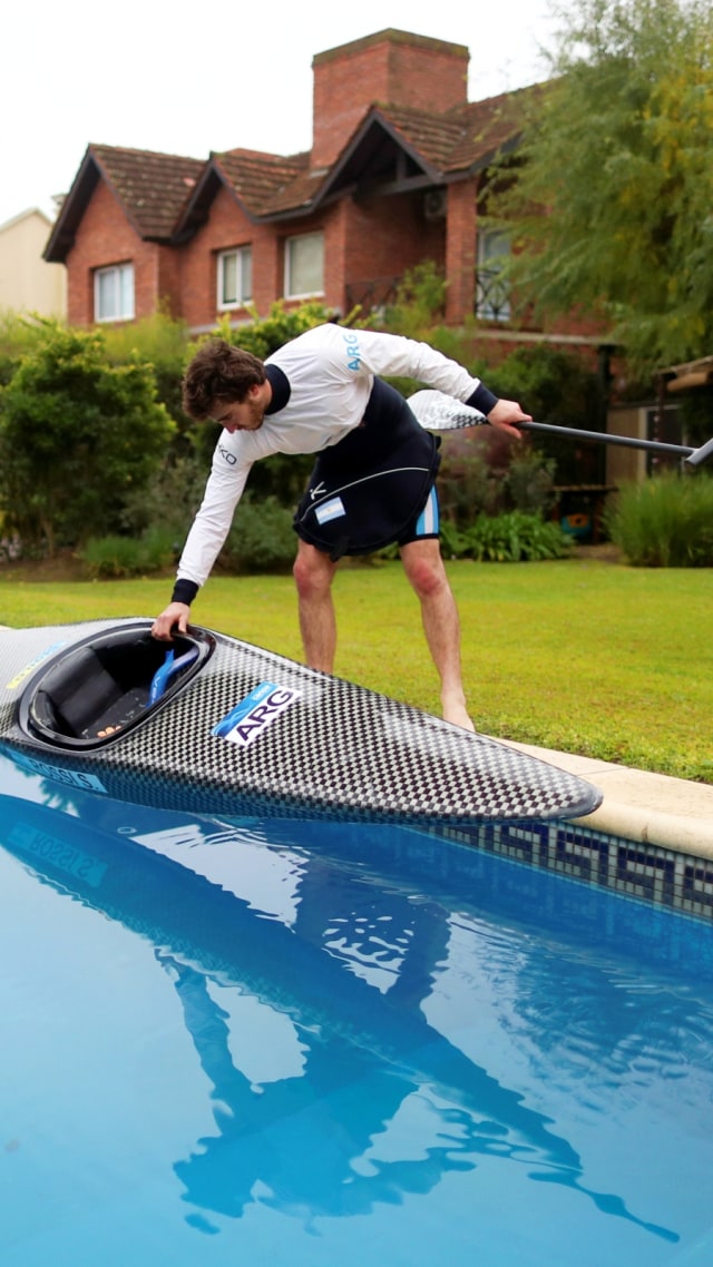 Sebastian Rossi menyiapkan perahu Kano saat berlatih di kolam renang rumah kekasihnya di Buenos Aires, Senin (8/6). Foto: Agustin Marcarian/Reuters