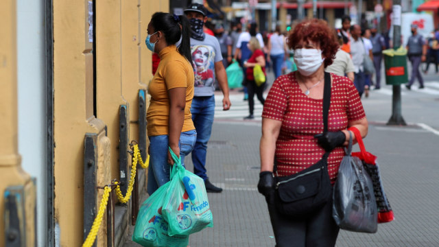 Sejumlah wanita mengenakan masker dan sarung tangan saat berada di salah satu pasar di Sao Paulo, Brasil, Rabu (10/6). Foto: Amanda Perobelli/Reuters