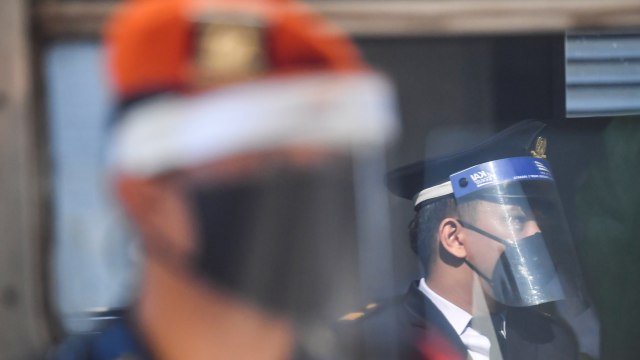 Petugas berjaga di samping Kereta Api (KA) Serayu di Stasiun Pasar Senen, Jakarta, Jumat (12/6).  Foto: ANTARA FOTO/Nova Wahyudi