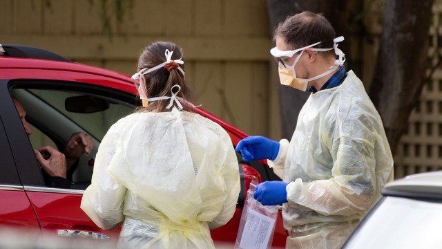 Petugas melakukan tes virus corona kepasa seorang pengemudi di Lower Hutt, Wellington, Selandia Baru.
 Foto: Marty MELVILLE / AFP