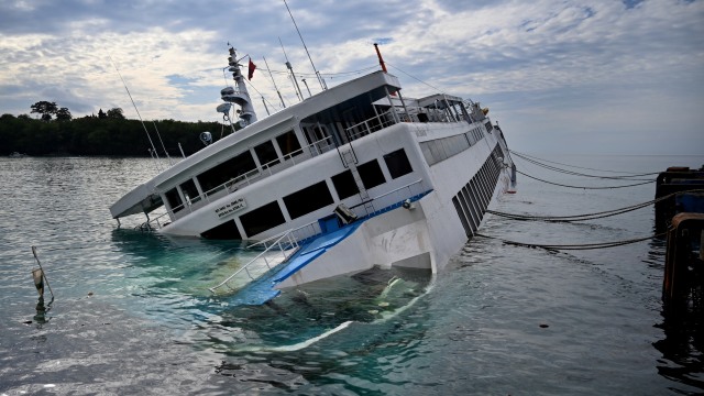 KMP Dharma Rucitra III berada dalam posisi miring hampir tenggelam di Dermaga 2 Pelabuhan Padangbai, Karangasem, Bali. Foto: SONNY TUMBELAKA / AFP