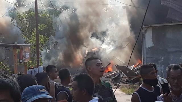 API membara saat warga berdatangan dan prajurit TNI AU berdatangan ke lokasi jatuhnya pesawat Hawk 209 di Perumahan Mutiara, Kubang Jaya, Siak Hulu, Kampar, Senin pagi, 15 Juni 2020. 
