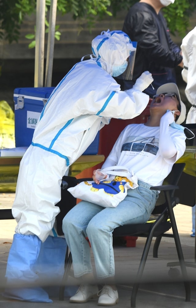 Petugas kesehatan melakukan tes swab di Beijing (16/6). Foto: NOEL CELIS / AFP
