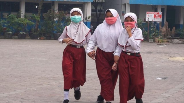 PARA murid SD di Pekanbaru mengenakan masker saat bersekolah. 