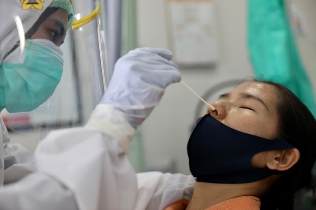 Seorang warga diambil sampel swab di Puskesmas Kuta Alam, Banda Aceh, Rabu (17/6/2020). Foto: Suparta/acehkini