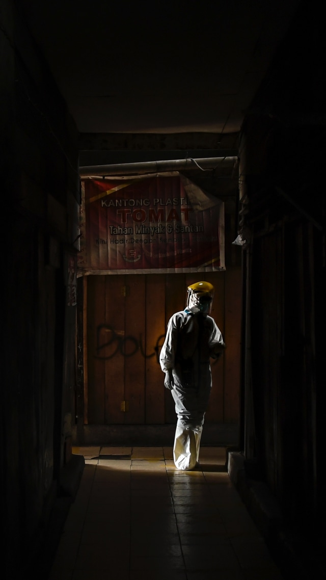 Seorang petugas kesehatan melintas di Pasar Thomas, Jakarta Pusat, Rabu (17/6), saat bersiap melakukan tes usap. Foto: Muhammad Adimaja/Antara