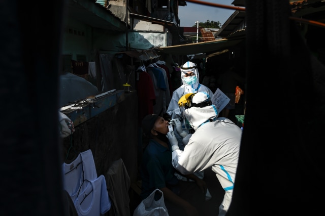 Sejumlah petugas kesehatan melakukan tes usap (swab test) kepada pedagang di Pasar Thomas, Jakarta Pusat, Rabu (17/6). Foto: Muhammad Adimaja/Antara