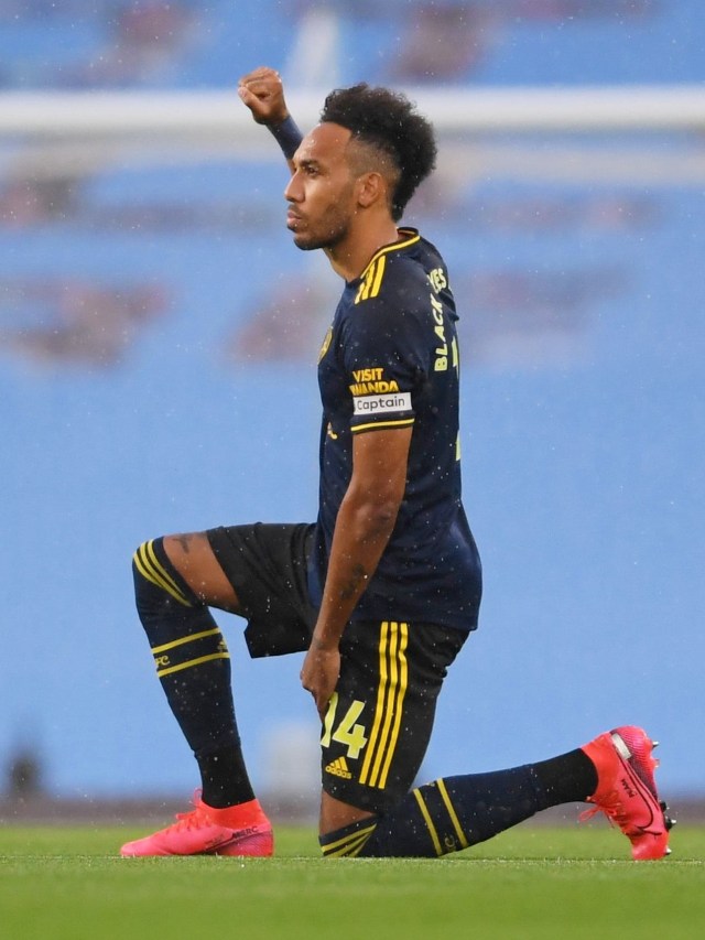 Pemain Arsenal, Pierre-Emerick Aubameyang, berlutut sebelum memulai pertandingan melawan Manchester City. Foto: Laurence Griffiths/Pool via Reuters