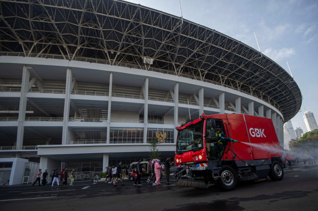 Petugas menyemprotkan cairan disinfektan di kawasan 'ring road' Stadion Utama Gelora Bung Karno (SUGBK) di Senayan, Jakarta, Minggu (21/6). Foto: Aditya Pradana Putra/ANTARA FOTO
