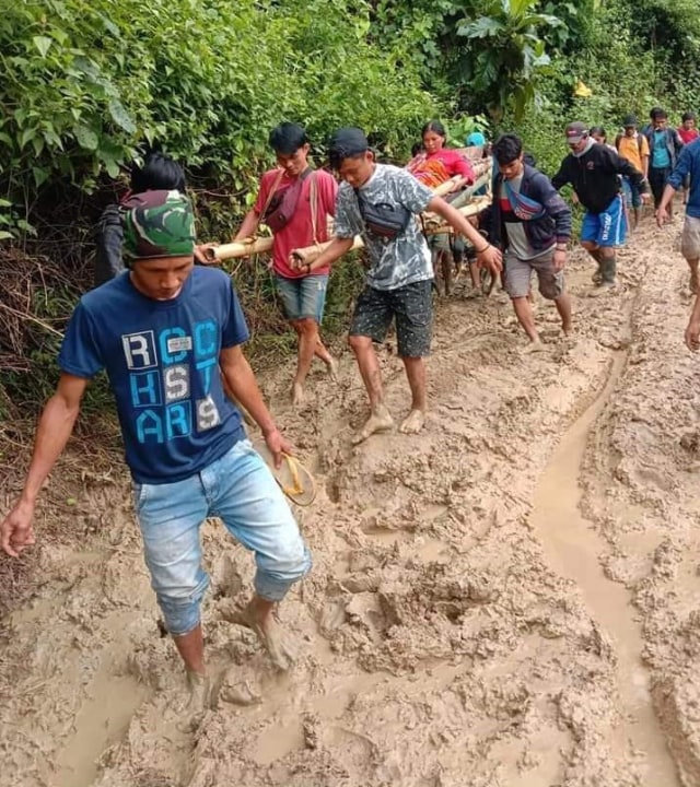 Warga Dusun Panasuan, Mamuju, menandu seorang ibu hamil sejauh 16 kilometer karena akses jalan rusak dan tidak bisa dilalui kendaraan. Foto: Dok. Istimewa