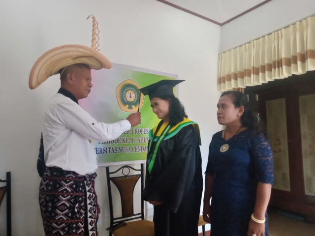 Foto : Adrianus Ndu Ufi didampinggi istri saat memindahkan kuncir milik anaknya, dr. Felin Aprilaineld Ndu Ufi, S.Ked.