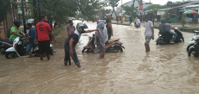 Tampak beberapa warga membantu melancarkan arus lalu lintas di perempatan Supermaket Jupiter, foto : Yanti