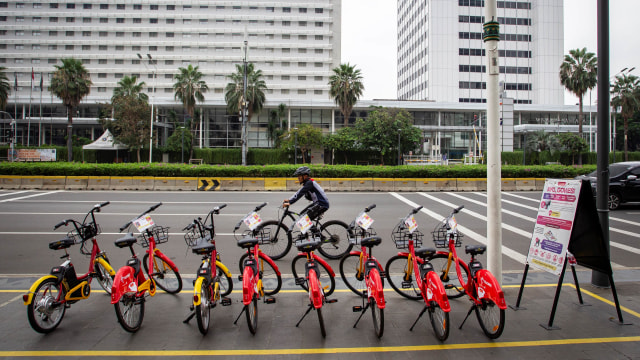 Warga berjalan di samping sepeda Gowes di kawasan Bundaran HI, Jakarta, Sabtu (4/7). Foto: Dhemas Reviyanto/ANTARA FOTO