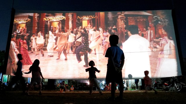 Sejumlah anak menonton film di daerah pedesaan di Tangerang Selatan. Foto: Willy Kurniawan/REUTERS