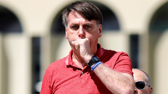 Presiden Brasil Jair Bolsonaro terlihat batuk-batuk saat menghadiri demonstrasi menentang lockdown di Brasilia, Brasil pada 19 April 2020. Foto: Sergio LIMA/AFP