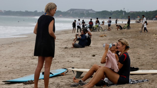 Sejumlah turis menikmati suasana pantai di Pantai Kuta Bali, Kamis (9/7). Foto: Firdia Lisnawati/AP Photo