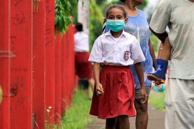 Seorang siswa SD dengan masker di wajahnya berjalan meninggalkan sekolah usai melakukan pendaftaran ulang pada hari pertama sekolah di Jayapura, Papua. Foto: Gusti Tanati/ANTARA FOTO