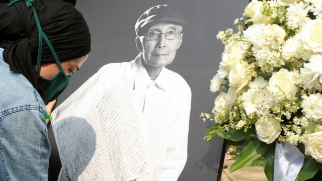 Anggota keluarga merapikan foto almarhum Sapardi Djoko Damono di rumah duka Ciputat, Tangerang Selatan, Banten, Minggu (19/7). Foto: Muhammad Iqbal/ANTARA FOTO