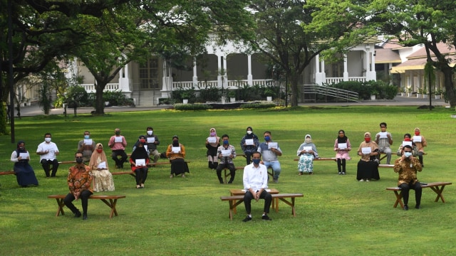 Presiden Joko Widodo berfoto bersama usai memberikan bantuan modal kerja kepada pedagang kecil yang terdampak COVID-19 di halaman tengah Istana Merdeka, Jakarta, Selasa (21/7/2020). Foto: Akbar Nugroho Gumay/ANTARA FOTO