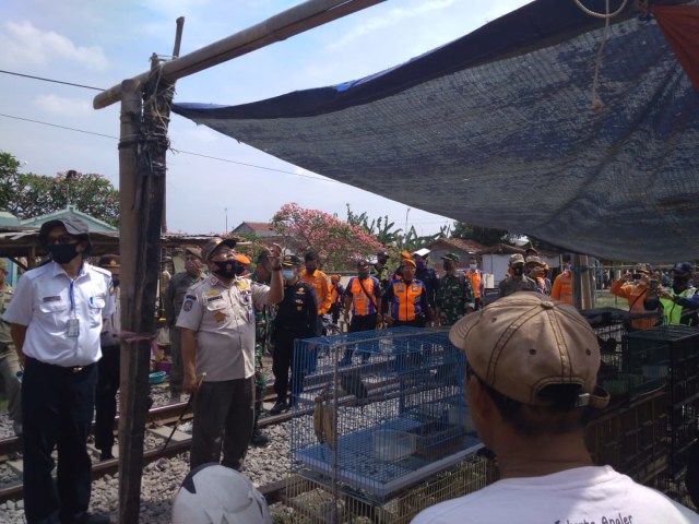 Petugas gabungan saat menertibkan pasar burung di jalur Kereta Api.