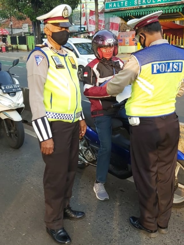 Polisi lalu lintas memberhentikan seorang pengendara sepeda motor melintas jalur Busway di Jalan Buncit Raya, Jakarta Selatan. Foto: Twitter/@TMCPoldaMetro