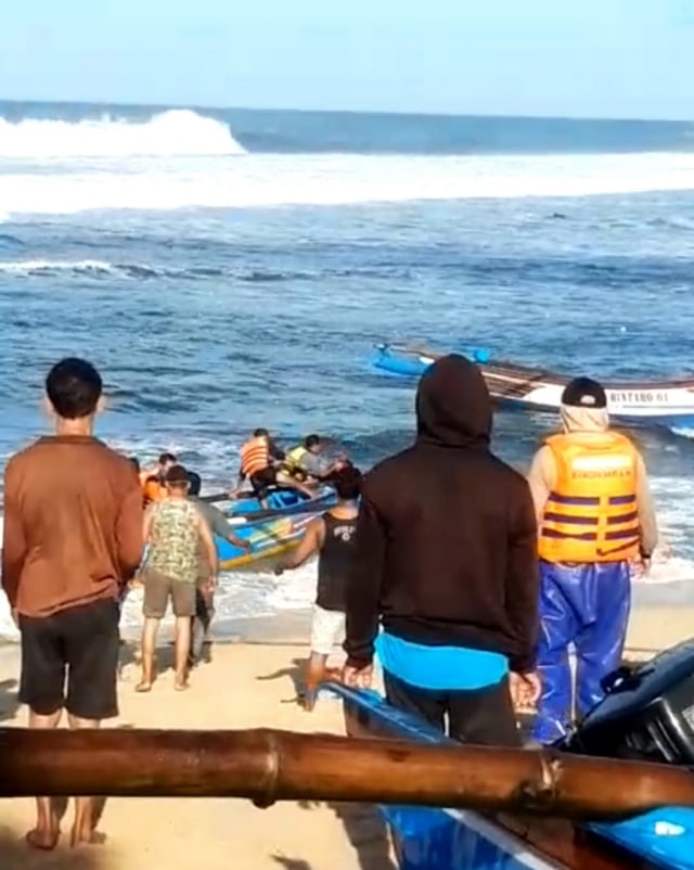 Tim SAR saat menyelamatkan nelayan di kapal jukung yang terbalik di Pantai Drini. Foto: Istimewa.