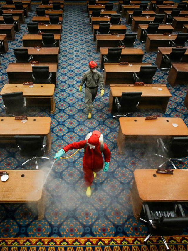 Petugas menyemprotkan cairan disinfektan di ruang sidang paripurna DPRD DKI Jakarta, Rabu (29/7). Foto: Rivan Awal Lingga/ANTARA FOTO