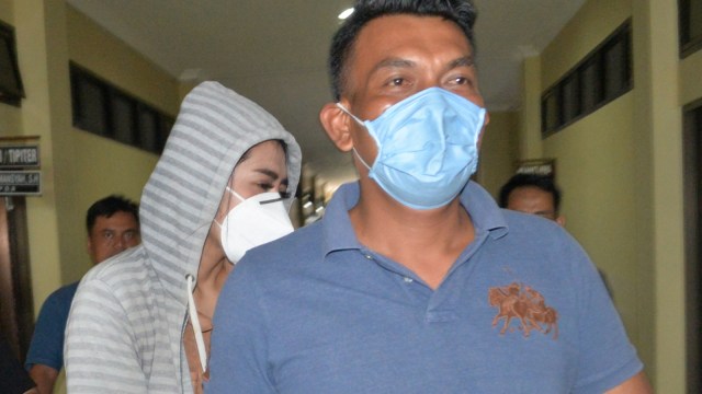 Personel kepolisian membawa artis berinisial VS (tengah) saat akan menjalani pemeriksaan di Polresta Bandar Lampung, Lampung, Rabu (29/7). Foto: Ardiansyah/ANTARA FOTO