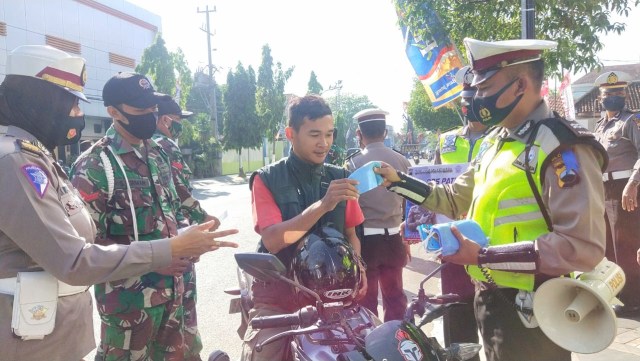 Anggota Polres Blora dan Kodim 0721 Blora, saat bagikan masker kepada pengguna jalan di Jalan Pemuda, tepatnya depan Makodim Blora. Kamis (30/07/2020)