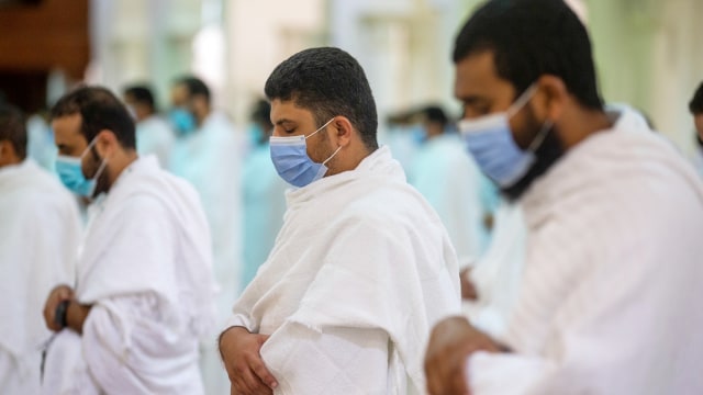 Jemaah haji mengenakan masker dan menjaga jarak saat salat di dalam Masjid Namira di Arafah, Makkah, Arab Saudi, Kamis (30/7). Foto: Saudi Ministry of Media/Handout