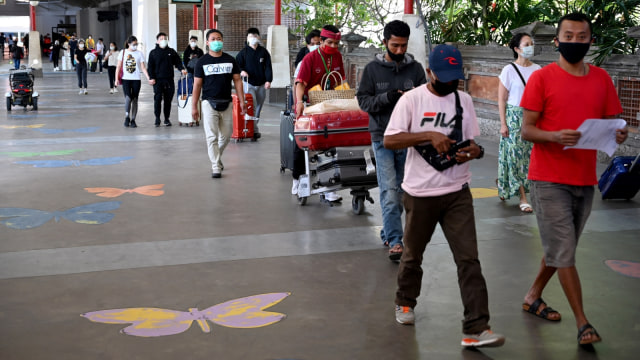 Penumpang tiba di Bandara Internasional I Gusti Ngurah Rai, Badung, Bali, Jumat (31/7). Foto: SONNY TUMBELAKA / AFP