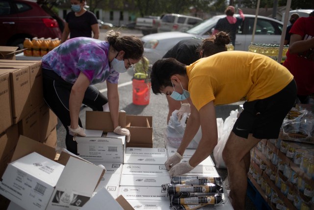 Ilustrasi warga membantu pasokan makanan dan kebutuhan untuk isoman. Foto: ADREES LATIF/REUTERS