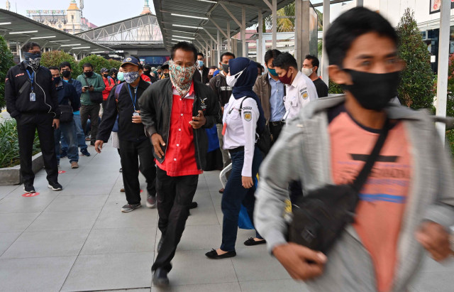Warga berlari di stasiun Bogor. Foto: Adek Berry/AFP