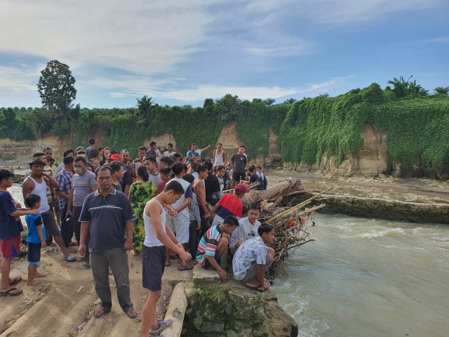 Warga menyaksikan proses evakuasi mayat tanpa identitas yang ditemukan di Sungai Bahbolon, Kabupaten Simalungun, Sumatera Utara. Foto: Istimewa