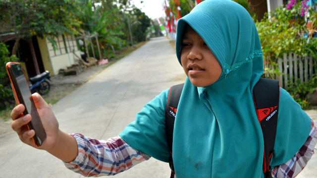 Siswa SMPN Plandaan mencari sinyal jaringan internet di Desa Marmoyo, Kecamatan Kabuh, Kabupaten Jombang, Jawa Timur, Selasa (4/8). Foto: Syaiful Arif/ANTARA FOTO