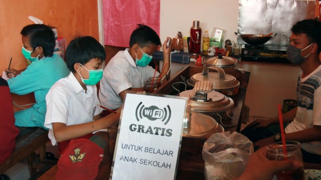Sejumlah pelajar sekolah dasar (SD) mengikuti pembelajaran jarak jauh dengan memanfaatkan jaringan internet gratis yang disediakan sebuah warung kopi di Jombang, Tangerang Selatan, Banten, Rabu (29/7). Foto: Muhammad Iqbal/ANTARA FOTO