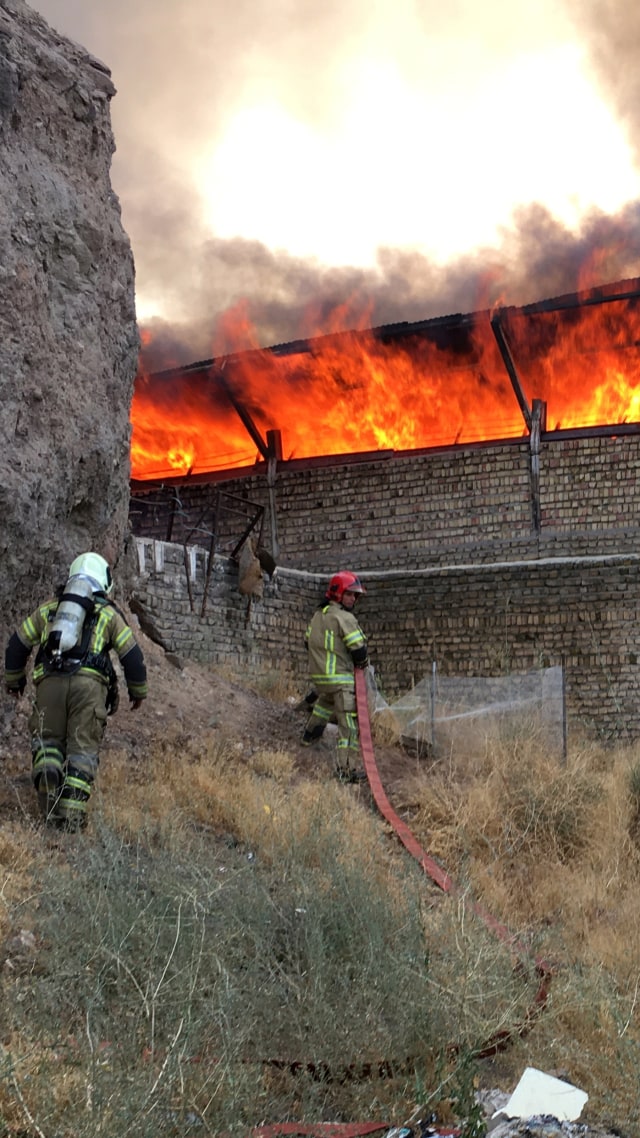 Petugas pemadam kebakaran memadamkan api yang meletus di kawasan industri Iran dekat Teheran, Iran, Selasa (4/8). Foto: WANA via REUTERS