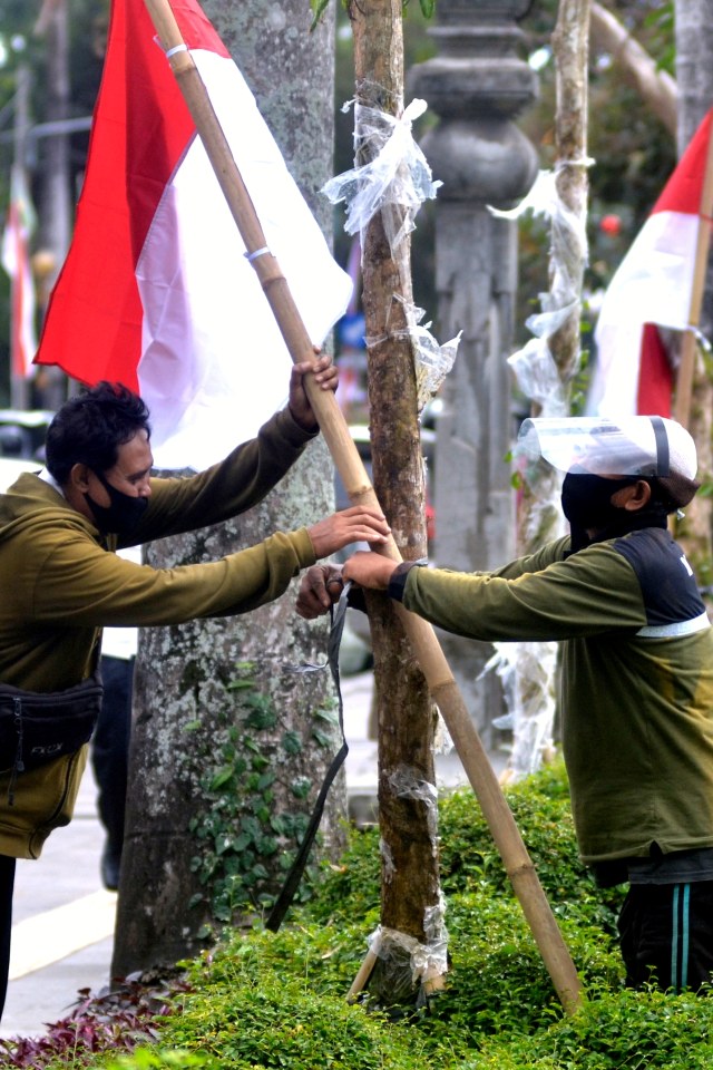 Petugas memasang bendera merah putih di kawasan Lapangan Puputan Badung, Denpasar, Bali, Rabu (5/8). Foto: Fikri Yusuf/ANTARA FOTO