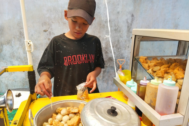 Darwin Jazilin (12) bocah kelas 1 Sekolah Menengah Pertama (SMP) itu harus rela membagi waktu belajar dan bermainnya untuk berjualan. Darwin membantu orang tuanya berjualan cilok untuk bisa membeli kuota internet untuknya belajar