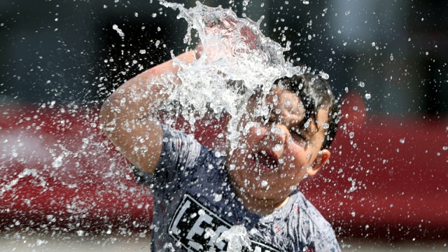 Seorang anak membasahi kepala dengan air mancur di pusat Kota Brussel, Belgia. Foto: Yves Herman/REUTERS