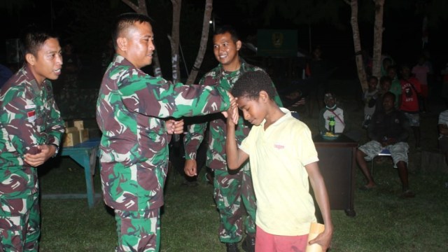 Satgas Pamtas RI-PNG Yonif Mekanis Raider 413 Kostrad menggelar layar tancap nonton bersama dengan warga Kampung Mosso, Distrik Muara Tami, Kota Jayapura, Papua, Minggu (9/8). Foto: Pen Satgas Yonif Mekanis Raider 413/Bremoro