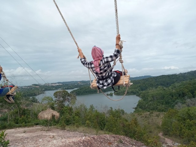 Pengunjung menikmati fasilitas Batam Swing di objek wisata Puncak Beliung. Foto: Zalfirega/kepripedia.com
