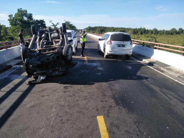 Minibus New Avanza dalam keadaan terbali usai tabrakan dengan Toyota Innova putih di Jembatan Tumbang Nusa, Kalimantan Tengah.