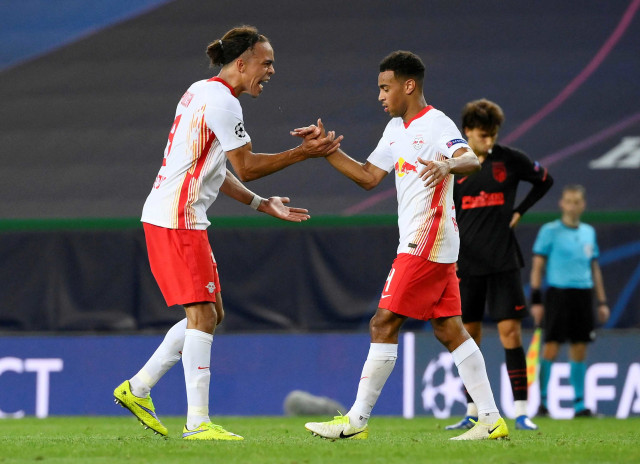 Pemain RB Leipzig Yussuf Poulsen dan Tyler Adams (kanan) melakukan selebrasi saat melawan Atletico Madrid. Foto: Lluis Gene/Reuters