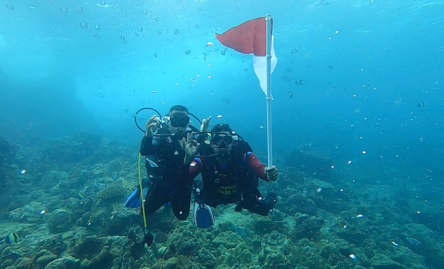 Personel Ditpolairud Polda Aceh mengibarkan bendera di bawah laut, nol kilometer, Sabang. Dok. Ditpolairud Aceh