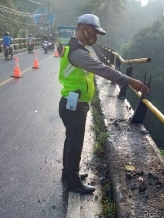 Polisi menunjukkan lokasi kecelakaan di seputar jembatan tukad melangit, Banjarangkan, Klungkung, Bali. Foto: Dok. NTMC Polri