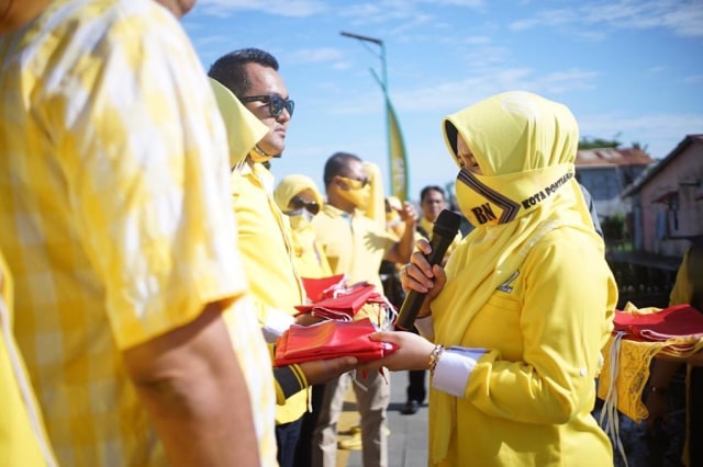 Ketua DPD Golkar Kota Pontianak menyerahkan bendera merah putih di HUT ke-75 RI kepada warga. Foto: Banyu Susanto/Hi!Pontianak