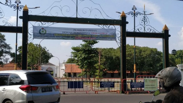 Pemberitahuan melalui spanduk terkait peniadaan Kirab Malam Satu Sura dipasang di gapura depan Pura Mangkunegaran Solo.  Foto: Aris Wasita/ANTARA
